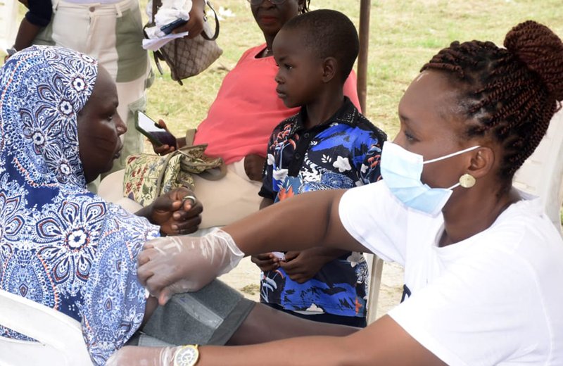 A healthcare volunteer checking blood pressure during a community outreach programme